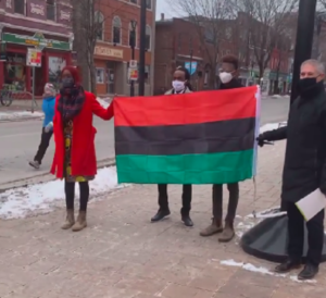 Three Black Lives Matter Fredericton organizers hold the Pan-African flag with Fredericton mayor.