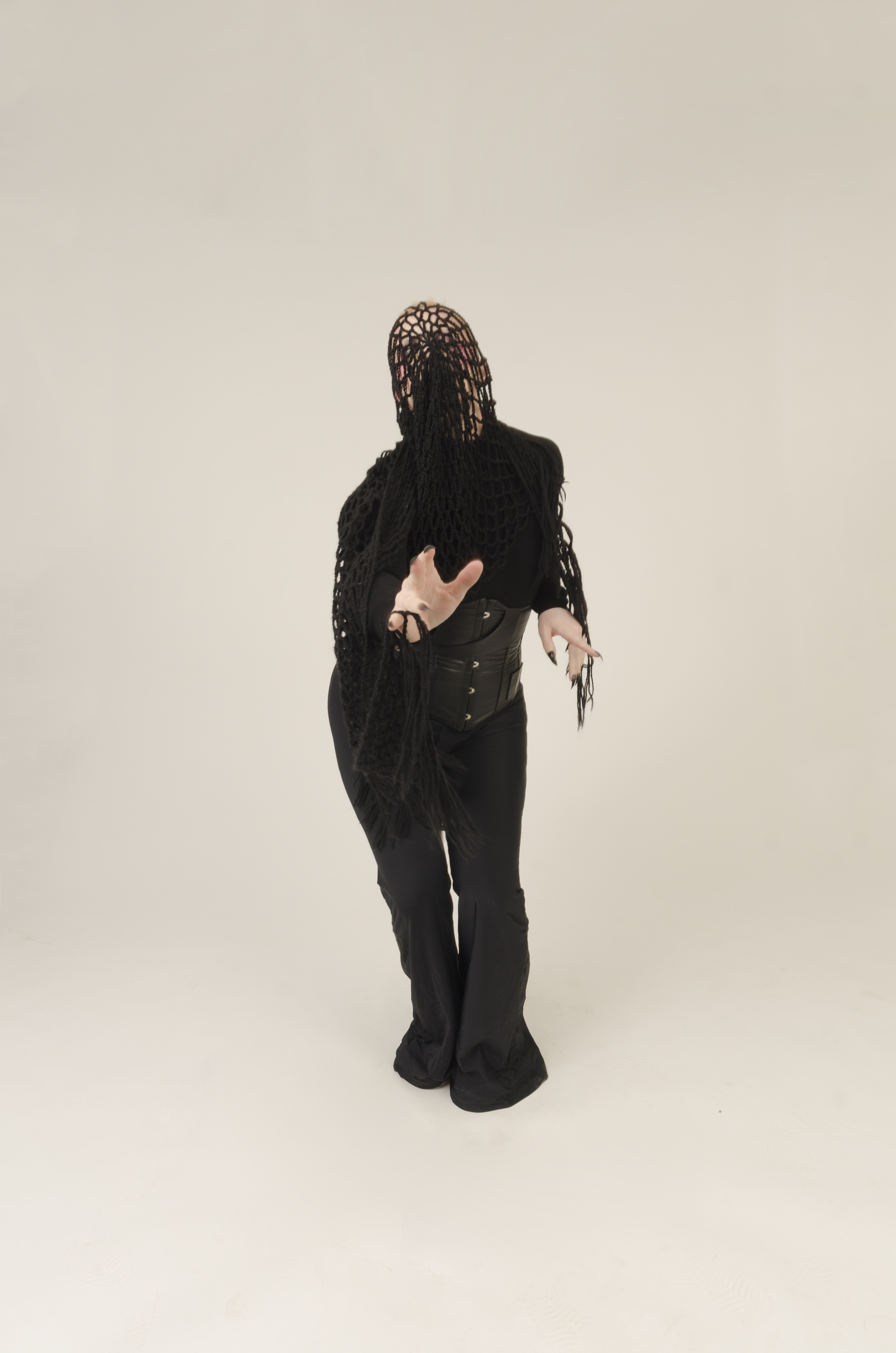 A person in a mesh net poses against a black background.