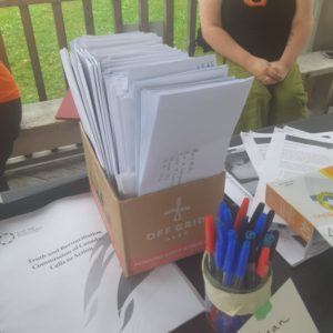 Letters in a cardboard box next to some pens.