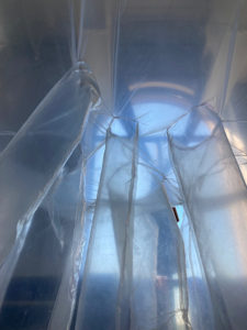 An inflatable plastic installation hung from the ceiling of a house.